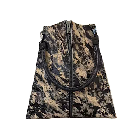 Camouflage-patterned bag with a black handle on a wooden surface with a tiled wall background